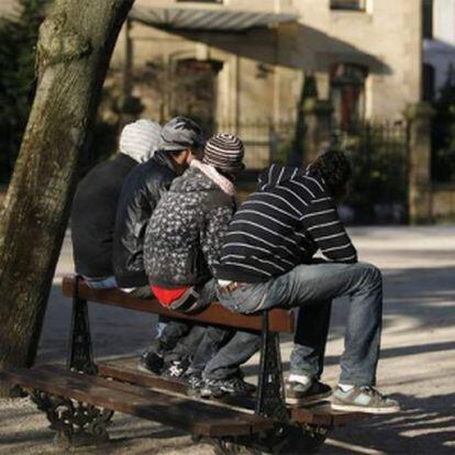 Un grupo de jóvenes, sentados en un banco.