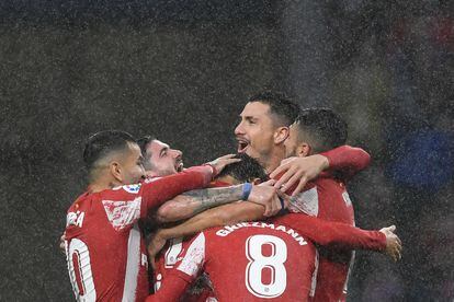 Los jugadores del Atlético celebran bajo la lluvia el gol de João Félix.