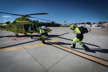 Tres sanitarios se dirigen a un helicóptero del Summa 112 en la base de Las Rozas.