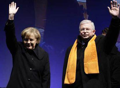 La canciller Angela Merkel y el primer ministro de Hesse, Roland Koch, saludan a los partidarios de la CDU en el acto de cierre de campaña.