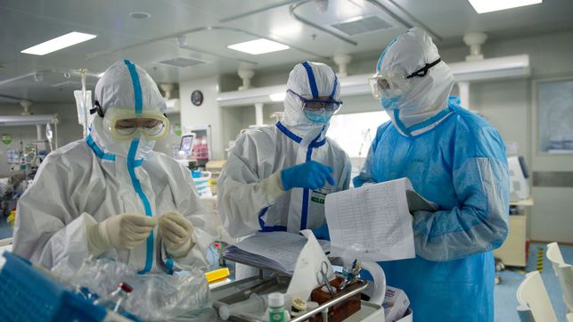 This photo taken on February 22, 2020 shows medical staff checking notes in an intensive care unit treating COVID-19 coronavirus patients at a hospital in Wuhan, in China's central Hubei province. - China on February 26 reported 52 new coronavirus deaths, the lowest figure in more than three weeks, bringing the death toll to 2,715. (Photo by STR / AFP) / China OUT