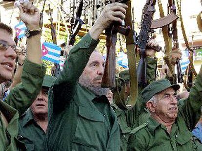 El presidente de Cuba, Fidel Castro (centro), levanta un fusil AK-47 durante la ceremonia de celebración de los 40 años de socialismo en la isla.