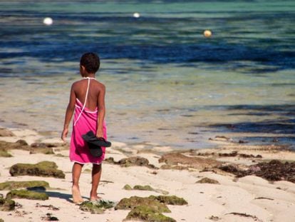 Una ni&ntilde;a fiyiana camina por la orilla.