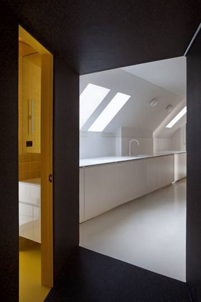 El acceso a la vivienda es un poliedro revestido de caucho negro y naranja que da paso, a un lado, al baño, y a la cocina (sin puerta), al otro. |