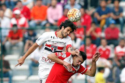 El mediocampista Hudson disputa el balón con Enrique Triverio.