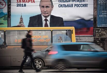 Un hombre pasa delante de un afiche electoral en favor de la candidatura del presidente de Rusia, Vlad&iacute;mir Putin, &quot;&iexcl;Un presidente fuerte, una Rusia fuerte!&quot;, en Crimea. 