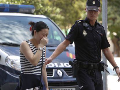 Una mujer llora junto al lugar donde fueron asesinadas una mujer y su nieta, supuestamente por una familiar esquizofr&eacute;nica.  