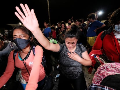 Dos mujeres hondureñas rezan antes de poner rumbo a Estados Unidos en una nueva caravana de migrantes que se formó en la noche del 9 de diciembre en San Pedro Sula.