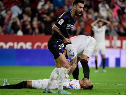 Sevilla's Moroccan forward Youssef En-Nesyri (down) lays on the ground next to Real Sociedad's Spanish midfielder Brais Mendez during the Spanish league football match between Sevilla FC and Real Sociedad at the Ramon Sanchez Pizjuan stadium in Seville on November 9, 2022. (Photo by CRISTINA QUICLER / AFP)