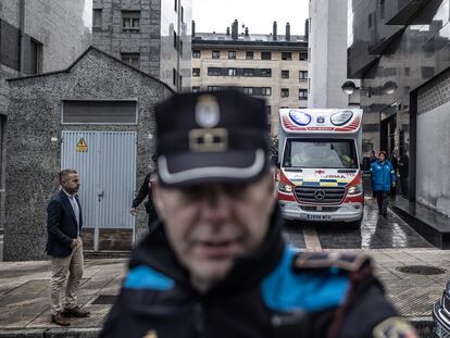 Policía local y servicios de emergencia, en la puerta del portal donde residían las menores que han fallecido en el barrio de La Ería, Oviedo (Asturias).