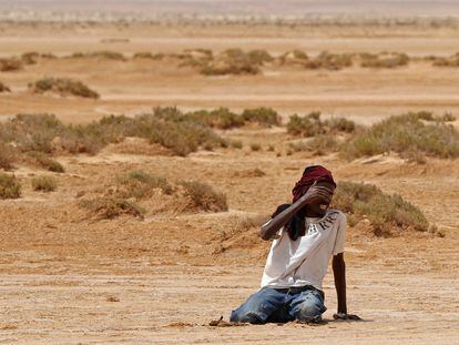 Un migrante de origen africano se desploma por agotamiento y deshidratación a su llegada a una zona deshabitada cerca de al-Assah, en la frontera entre Libia y Túnez, el pasado 30 de julio.