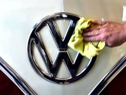 Una persona limpia el símbolo de la marca de coches Volkswagen.