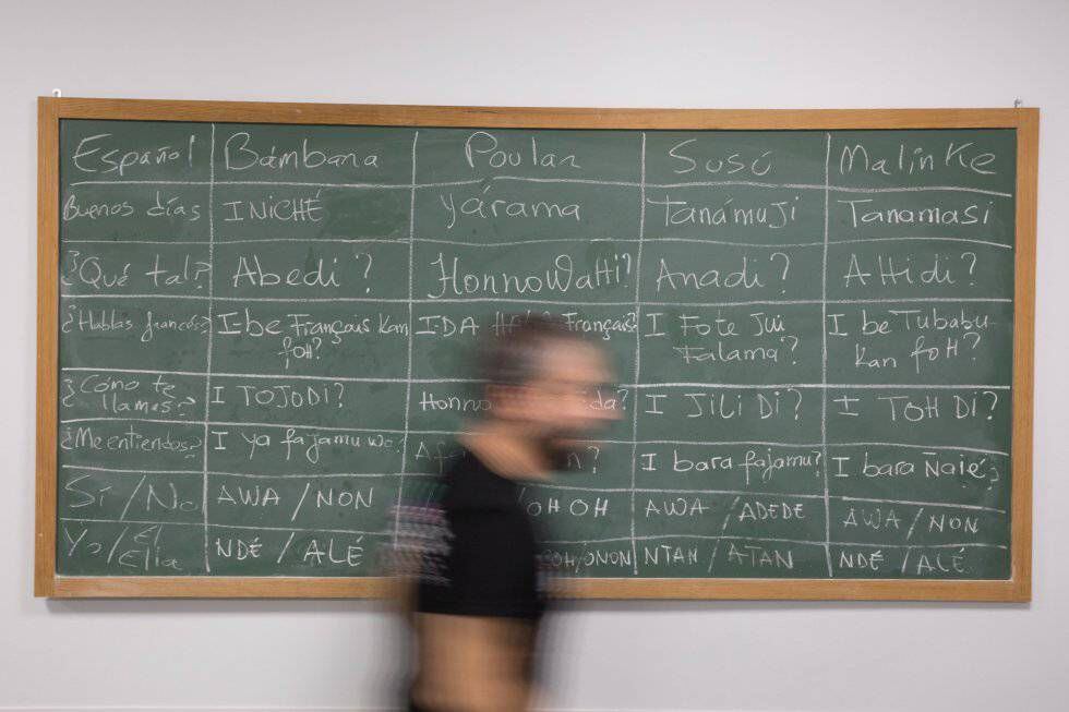 Ignacio Peña pasa por delante de una pizarra con varios idiomas africanos.