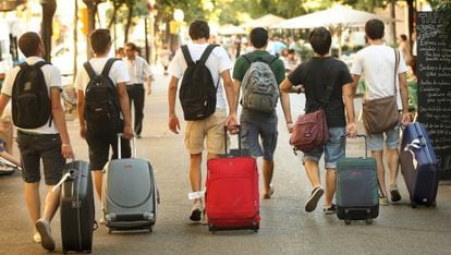 Un grupo de turistas camina con sus maletas por la Rambla de Cataluña, en Barcelona.