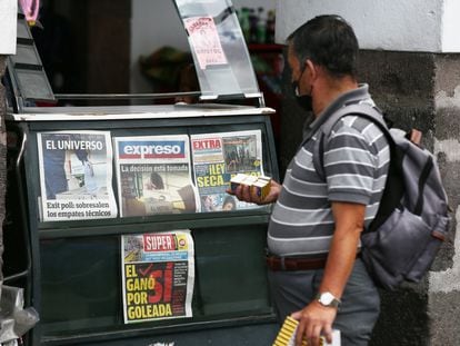 Un hombre observa las portadas de los periódicos tras la jornada electoral en Ecuador.