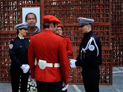 Agentes de la policía francesa y de la Ertzaintza conversan delante de una fotografía de Jean-Serge Nérin, policía galo asesinado por ETA. El Parlamento vasco ha rendido homenaje a Nérin.