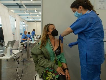 Una enfermera administra una dosis a una mujer en la Fira de Barcelona, donde se vacuna a personas de 55 a 59 años.