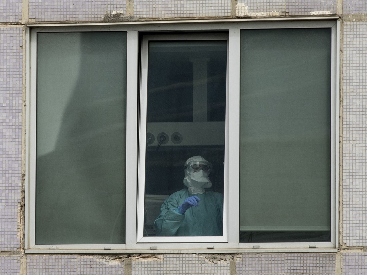 Un sanitario, en una de las ventanas del Hospital Universitario La Paz de Madrid 