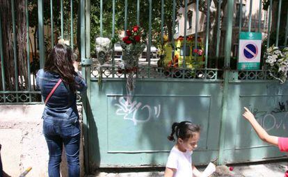 Padres de alumnos colocan flores en la verja del colegio.