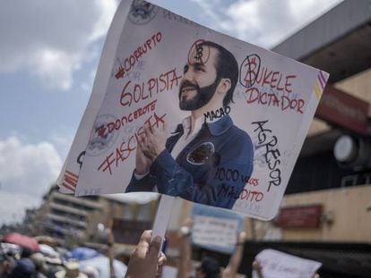 Un manifestante levanta una pancarta en contra de Nayib Bukele, durante una protesta en San Salvador.