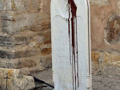 Una lápida en la misión de Carmel, profanada con pintura marrón.