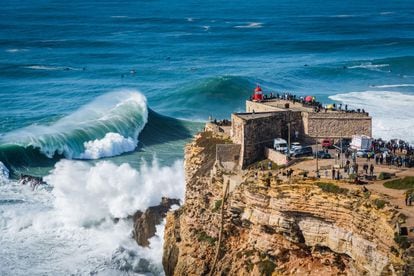 Un grupo de personas contempla las olas gigantes, de hasta 30 metros, desde el faro del puerto portugués de Nazaré, uno de los destinos mundiales más famosos del surf. 