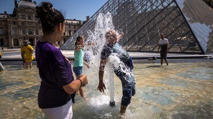 Unas personas se refrescaban el martes en una de las fuentes del Museo del Louvre, en París.