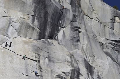 El californiano Kevin Jorgeson de verde, y Tommy Caldwell, de azul (a su derecha, un poco más abajo), cercanos a culminar el ascenso a El Capitán, el pasado 14 de enero, en una toma desde el suelo del valle. Los dos escaladores, de 30 y 36 años respectivamente, se han convertido en los primeros en subir en estilo libre esta pared, considerada la más dura del planeta.