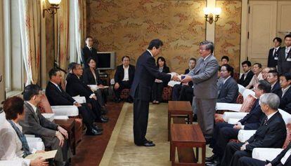 El portavoz del Parlamento japonés, Takahiro Yokomichi (a la derecha), recoge el informe sobre el accidente en la central nuclear de Fukushima.