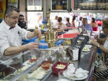 Un camarero tira una caña en un bar de Sevilla.