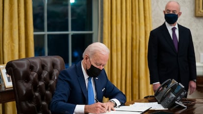 El secretario de Seguridad Nacional Alejandro Mayorkas acompaña al presidente Joe Biden mientras firma una orden ejecutiva en la Casa Blanca.