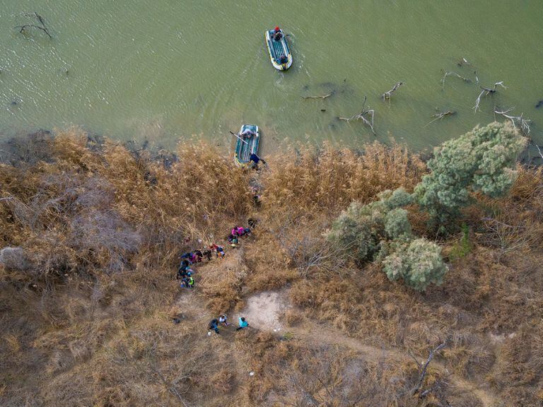 Families and minor migrants cross the Bravo River in Texas.