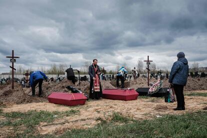 Un sacerdote oficia un funeral por varios muertos tras los ataques de las tropas rusas en la ciudad de Bucha, el 18 de abril.