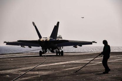 Uno caza de combate F18 Hornet aterriza en la cubierta del portaaviones USS Harry S. Trumna, el 8 de mayor de 2018.