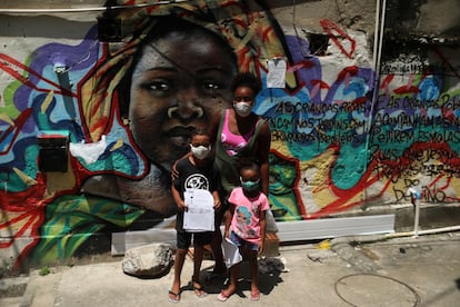Janice Delfim, fundadora de una iniciativa para facilitar el acceso a la educación de los niños perjudicados por el cierre de escuelas por la covid-19, posa con dos de las beneficiarias de su proyecto, en la favela Prazeres de Río de Janeiro, en Brasil.