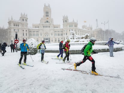 Un grupo de esquiadores pasa junto a Cibeles durante la nevada Filomena.