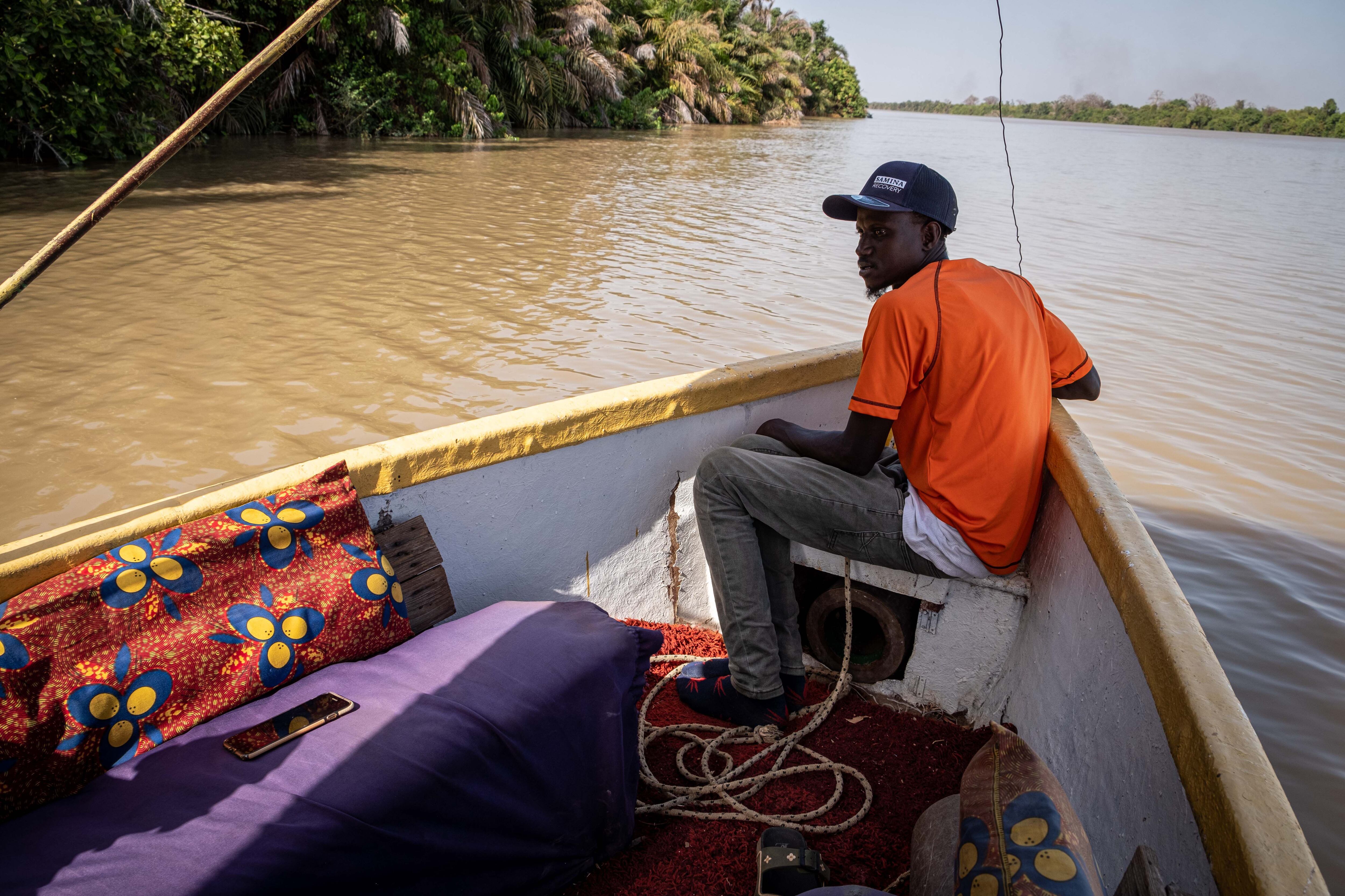 Jalamang Danso, un gambiano que trabaja de guía turístico, navega en su barca por el río Gambia.