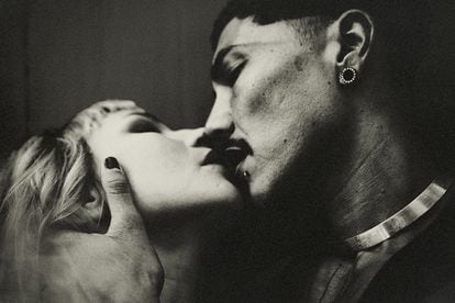 Un pareja joven besándose.