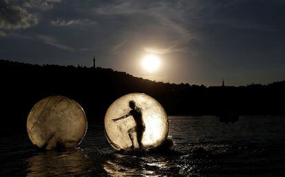 Varias personas juegan dentro de bolas de plástico gigantes, llamadas Zorb, en el río Vltava de Praga (República Checa).