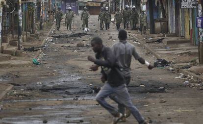 Dos partidarios del opositor Odinga se enfrentan a la Policía, este sábado en un suburbio de Nairobi.