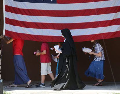 Una monja católica camina con niños durante la celebración del Día de la Independencia en el Convento de las Hijas de María en Round Top, Nueva York.