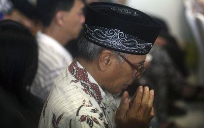 Familiares de los pasajeros del QZ8501 rezan mientras esperan noticias en Surabaya.