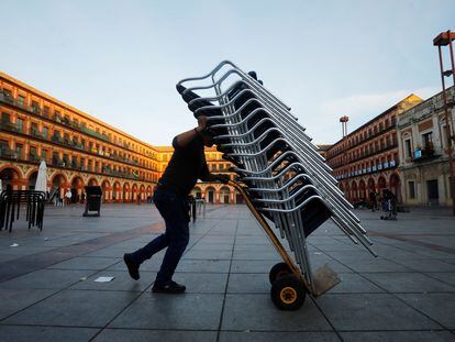 Un trabajador recoge la terraza de su bar en Córdoba el pasado 20 de julio.
