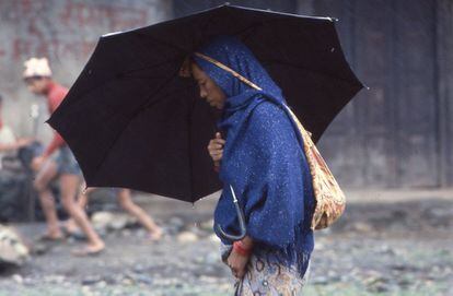 Mujer nepalí protegiéndose de la lluvia