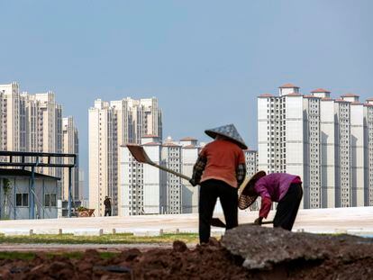 Unos trabajadores delante de unas torres en construcción, en China.