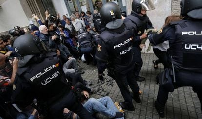 Polic&iacute;as dispersan a un grupo de ciudadanos el 1 de octubre en Barcelona.