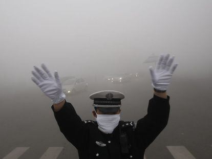 Un policía de tráfico se protege de la contaminación en la ciudad china de Harbin, en una imagen de archivo de octubre de 2013.