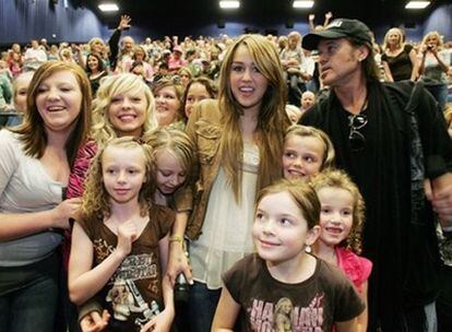Miley Cyrus junto a su padre, Billy Ray Cyrus, posan con sus fans en un cine de Utah el viernes 10 de abril de 2009.