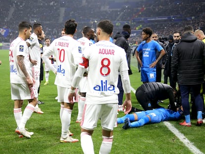 El capitán marsellés Dimitri Payet, en el suelo, tras recibir un botellazo en la cabeza al inicio del Lyon-Olympique de Marsella, este domingo.