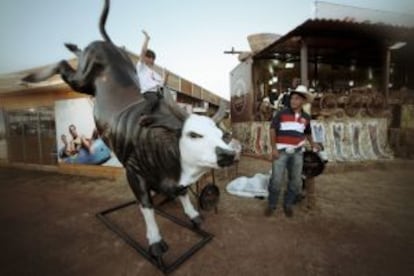 Un niño ensayando la postura del 'cowboy' en una réplica de toro.